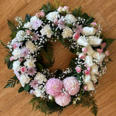 Classic Wreath in White -SYM-321 - This classic wreath made with mixed white and cream flowers is suitable for a lady or a gentleman. This type of funeral arrangement needs at least one working days’ notice for delivery. Same day delivery is not possible.